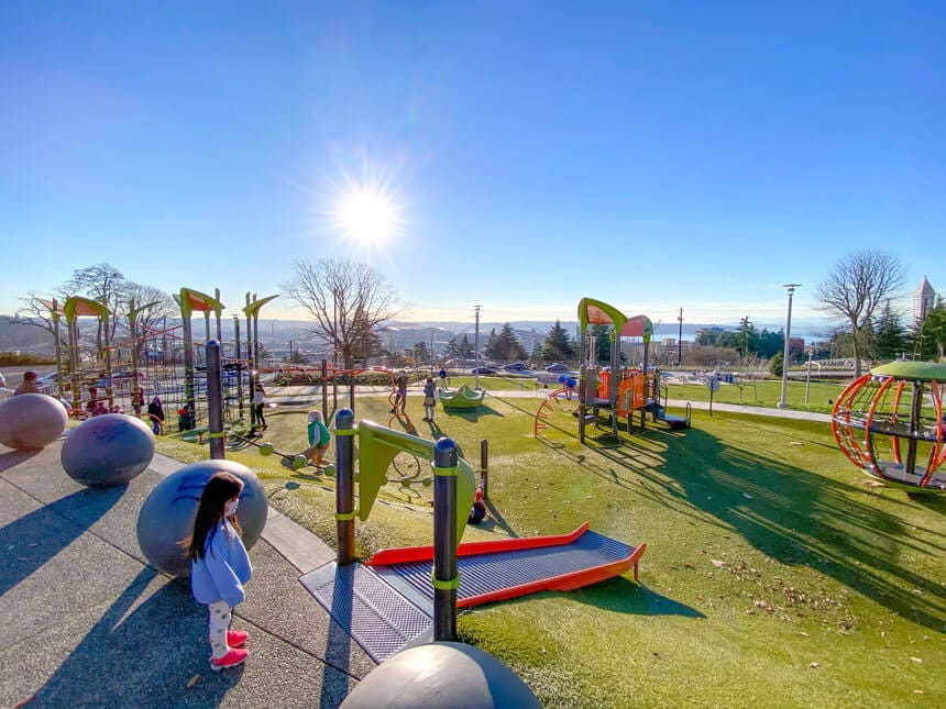 Yesler Terrace Park view of Seattle and playground, with a young girl looking at the playground.