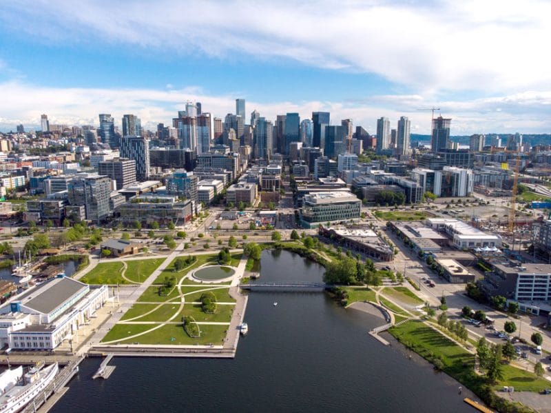 Lake Union Park with the South Lake Union neighborhood in the background, home to Amazon’s global headquarters and major Google offices, showcasing Seattle’s transformation into a vibrant, walkable tech hub with green spaces and waterfront access.
