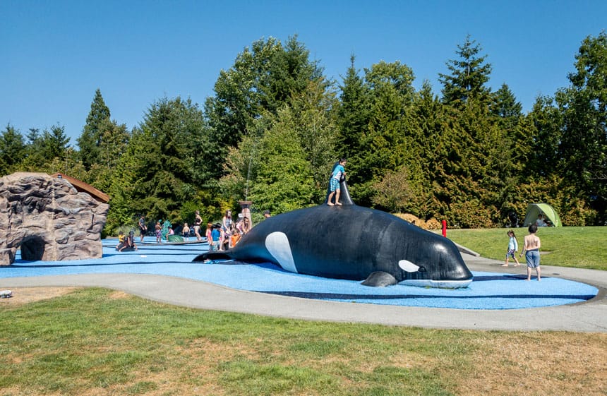 Crossroads Park Playground Big Orca Splash Pad with Kids Sliding Down the Front