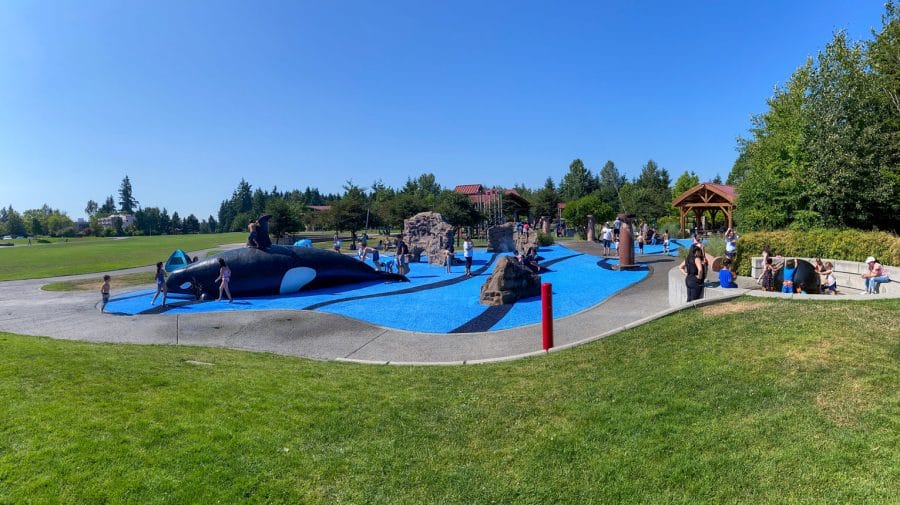 Kids Hopping on the back of a spouting Orca whale at the Crossroads Water Spray Playground