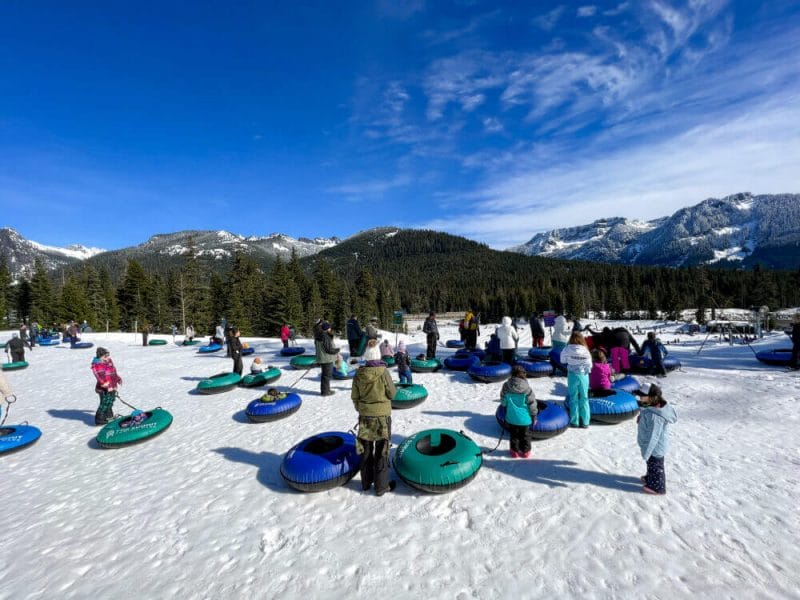 Kids tubing down the snowy hill at The Summit at Snoqualmie in Washington, bundled up in winter gear and smiling as they enjoy one of the area’s most popular family-friendly snow activities. With groomed lanes, a dedicated tubing lift, and stunning mountain views, it’s the perfect spot for kids and parents to experience the thrill of snow tubing together.