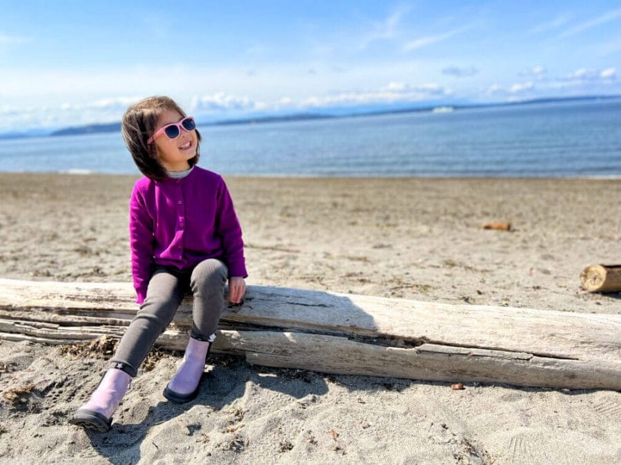 Toddler Sitting on Driftwood at Alki Beach in Seattle