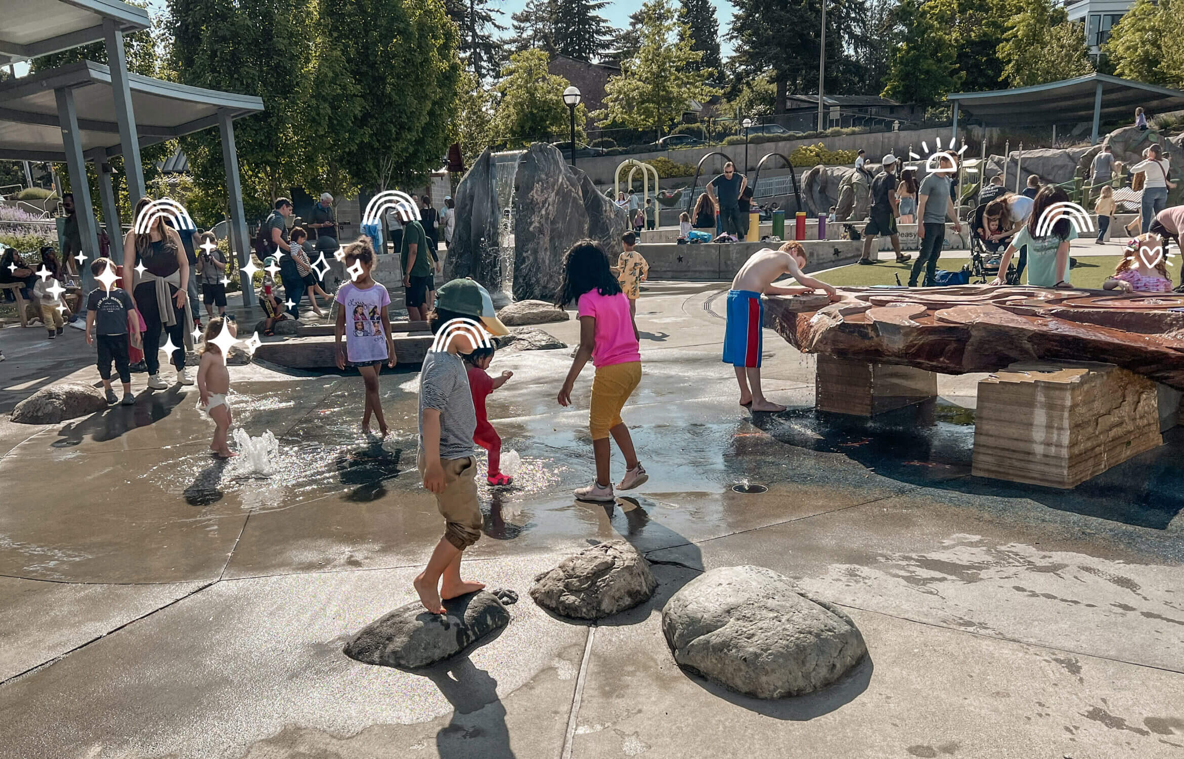 Bellevue Downtown Park splash pad, open to all during the summer, featuring a mini waterfall and water table, perfect for toddlers.