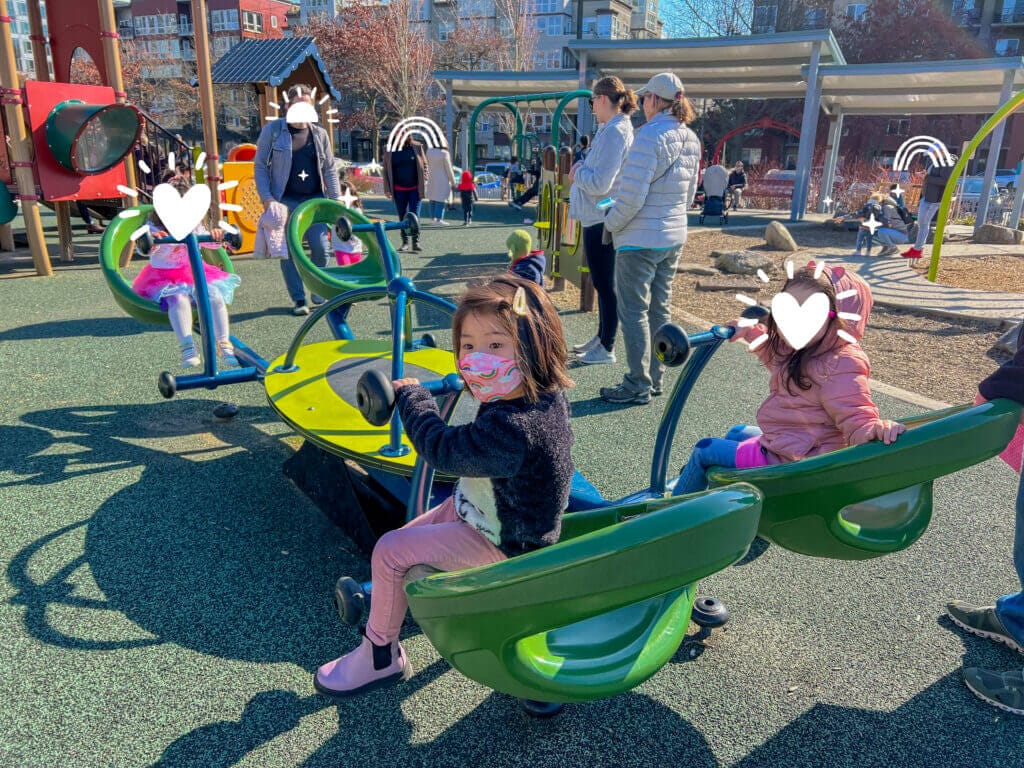 Bellevue Downtown Park Playground features a unique four-seater seesaw where kids can laugh and play together, surrounded by safe rubber ground and modern play structures—perfect for collaborative fun and social play.