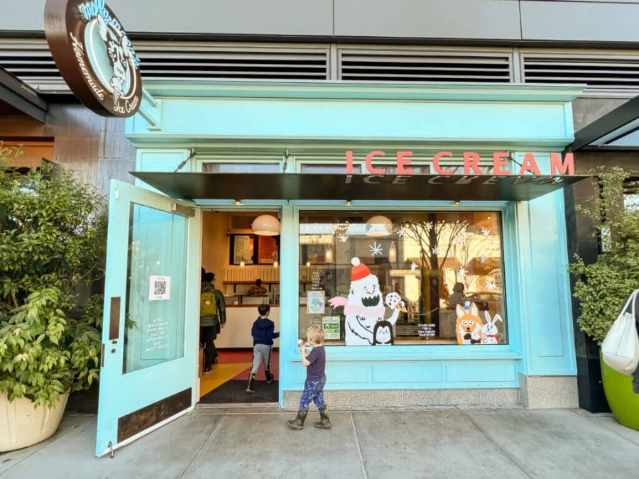 Molly Moon's Uvillage store front, little boy walking infant of the iconic teal colored ice cream shop.