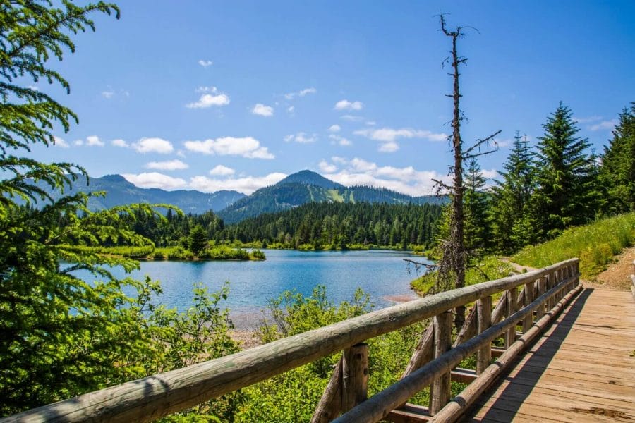 Beautiful Landscapes of Gold Creek Pond Snoqualmie Washington with wooden bridge in the foreground and lake and evergreen trees in the background