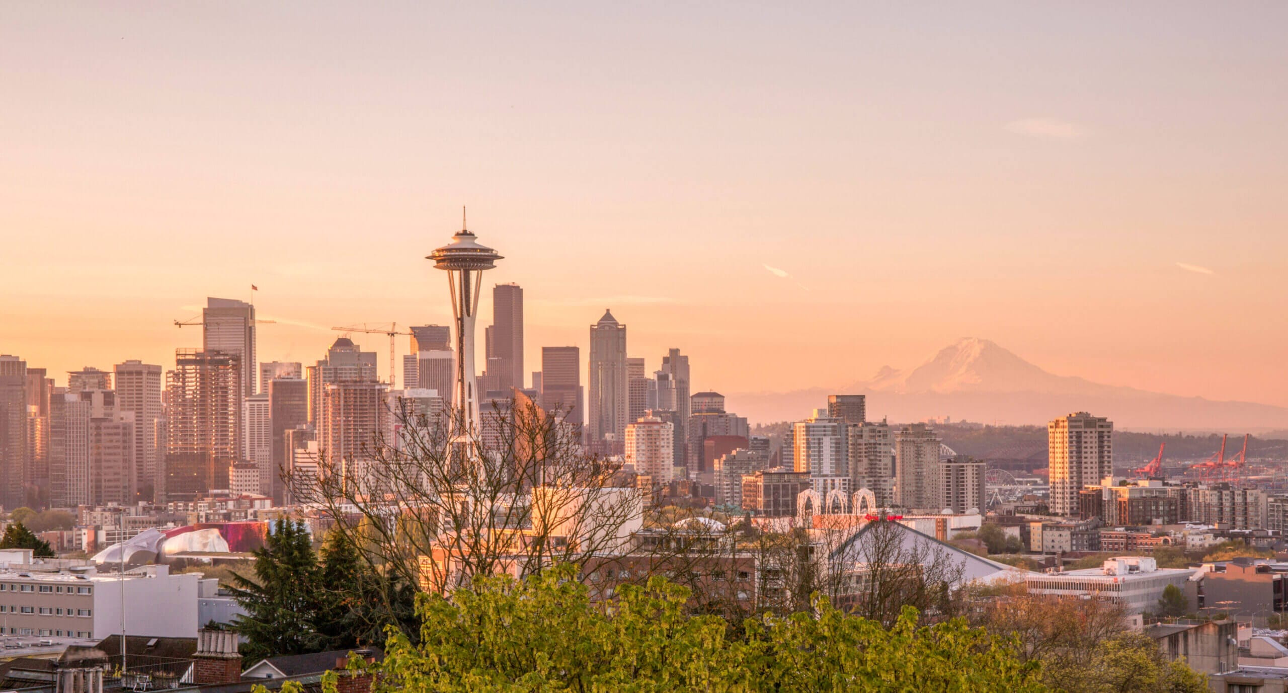 Kerry Park is a must-visit for Seattle visitors or locals, offering iconic views of the city skyline and Mount Rainier, especially stunning at sunset with an orange glow.