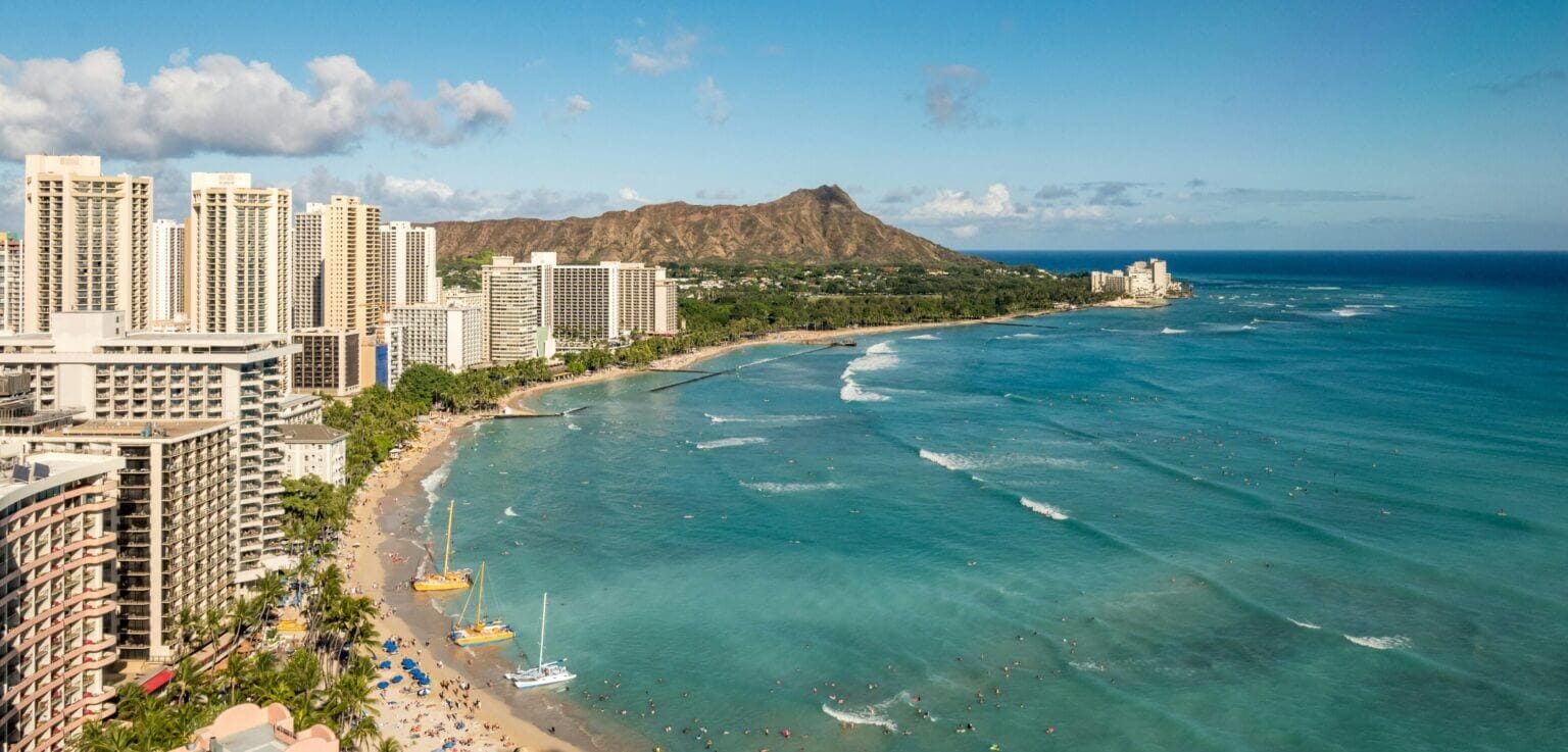 Aerial view of Waikiki Beach with Diamond Head in the background, the perfect place for kids to learn how to surf. A top activity to do with kids on Oahu.