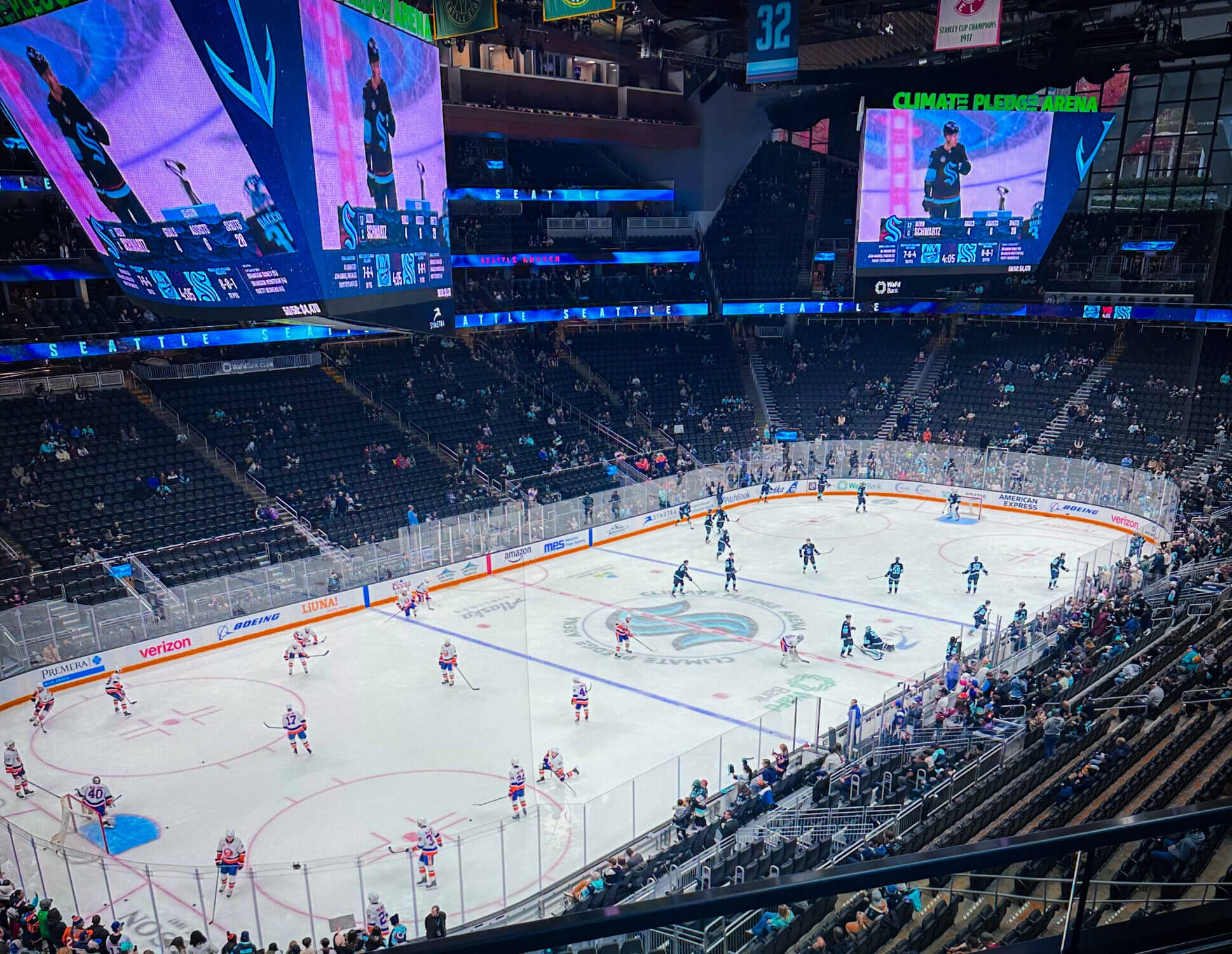 A full view of the ice rink at Climate Pledge Arena from the back of the stadium, as the Seattle Kraken take the ice for an action-packed game. For families wondering if a Seattle Kraken game is kid-friendly, the answer is yes! The high-energy atmosphere, thrilling plays, and three fast-paced periods make the experience exciting for hockey fans of all ages.