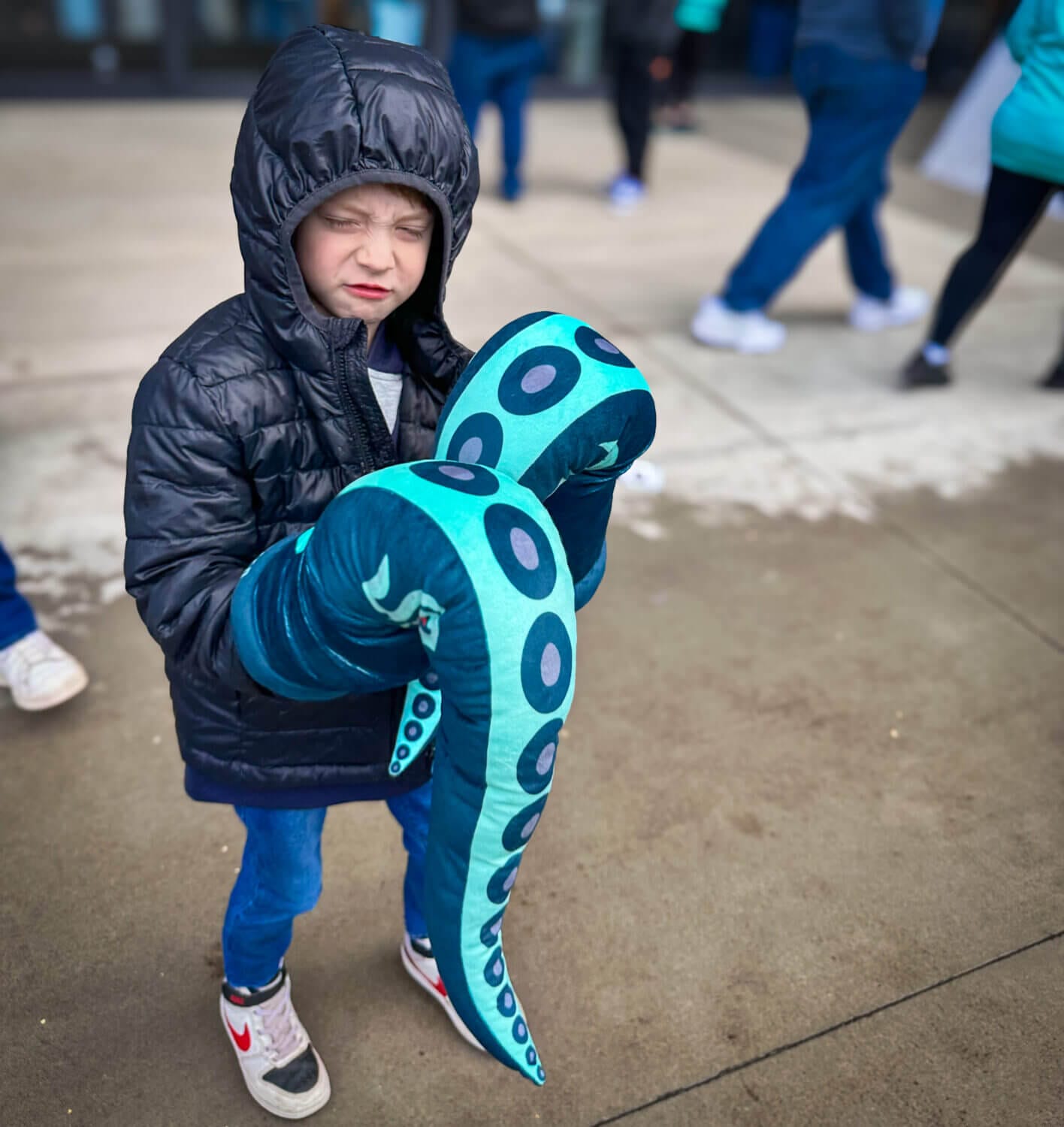 A young boy excitedly wears the Seattle Kraken hand tentacle gloves on both arms before the big game, ready to cheer on his favorite team. Attending a Kraken game is an unforgettable experience for young fans, jump into our guide to see tips and tricks on how we made the most of it with our kids.