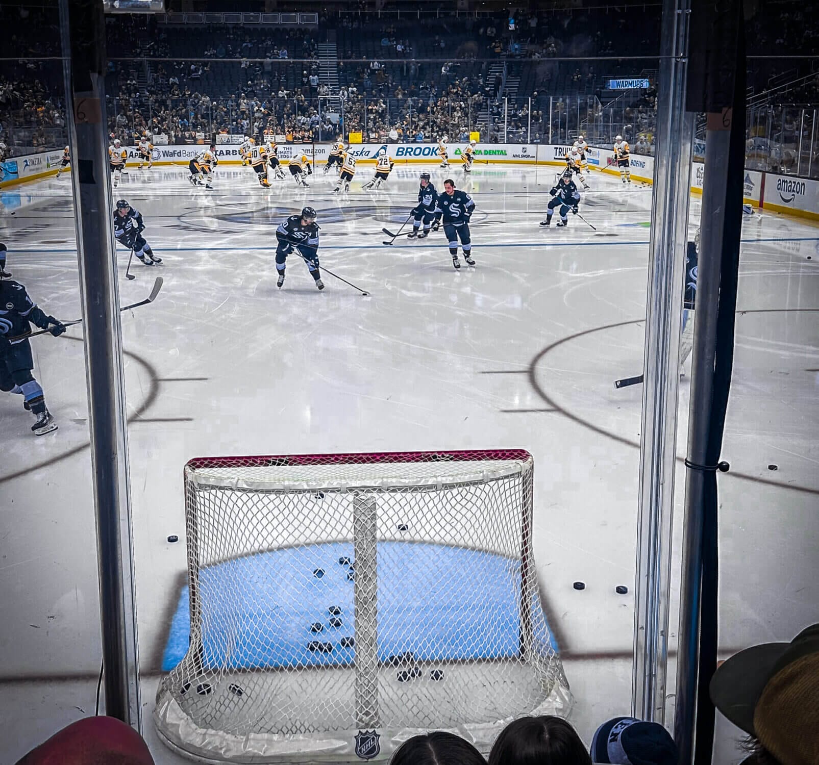 Close-up view of the Seattle Kraken players warming up before the big game at Climate Pledge Arena. As we headed to sections 20 and 21, we were able to get right up against the glass, giving our kids an up-close experience with their favorite players.