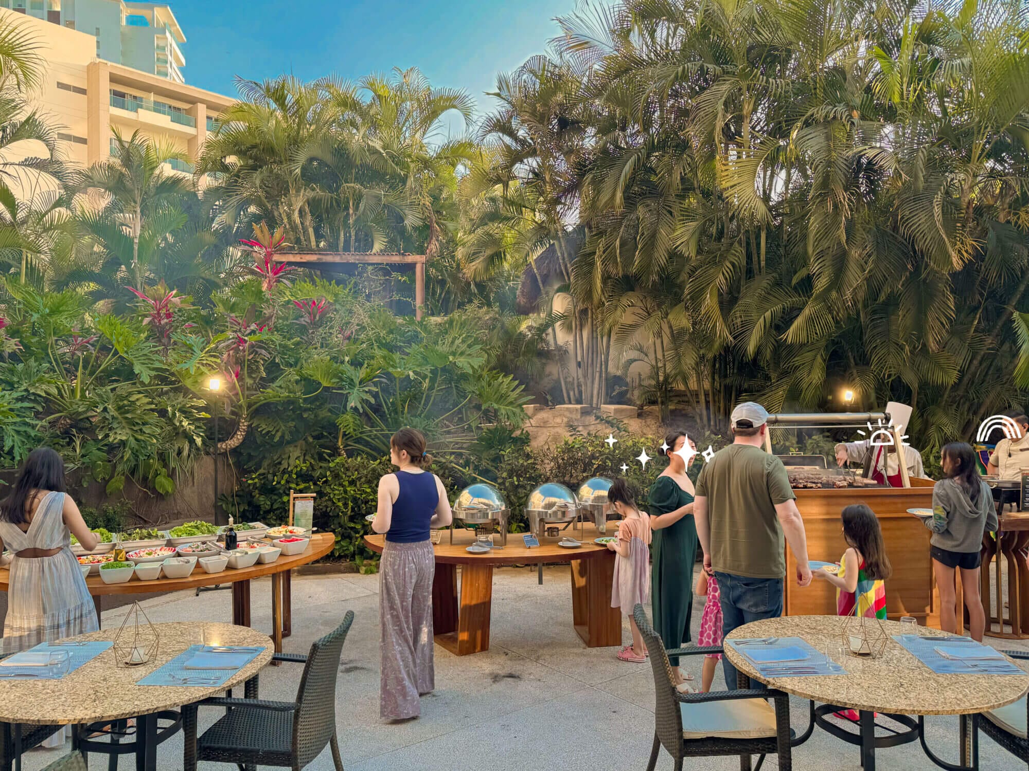 Guests line up at the outdoor buffet at Carnival, the international restaurant at Dreams Vallarta Bay Resort, on a BBQ-themed dinner night. The buffet offers a wide variety of sides including grilled vegetables, hot dishes, and even kid-favorite French fries—ensuring there’s something for everyone. Inside, families will find a dedicated kids’ station with familiar favorites like quesadillas, pasta, and nuggets, making dinner time easy and fun for little ones. With rotating nightly themes and a relaxed, festive atmosphere, Carnival is a highlight of the all-inclusive dining experience.