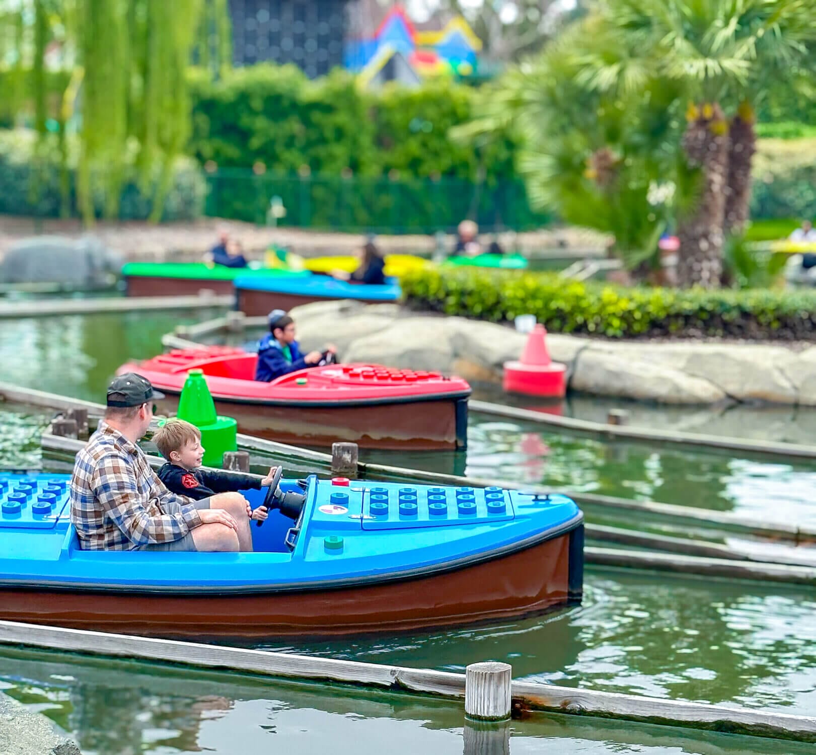 Dad and son steer their LEGO-themed boat together at Skipper School in LEGOLAND California, a gentle and interactive boat ride where young kids ages 3–5 can ‘drive’ through a winding water course. This hands-on attraction is perfect for toddlers and preschoolers, offering just the right balance of fun and independence in a safe, guided environment.