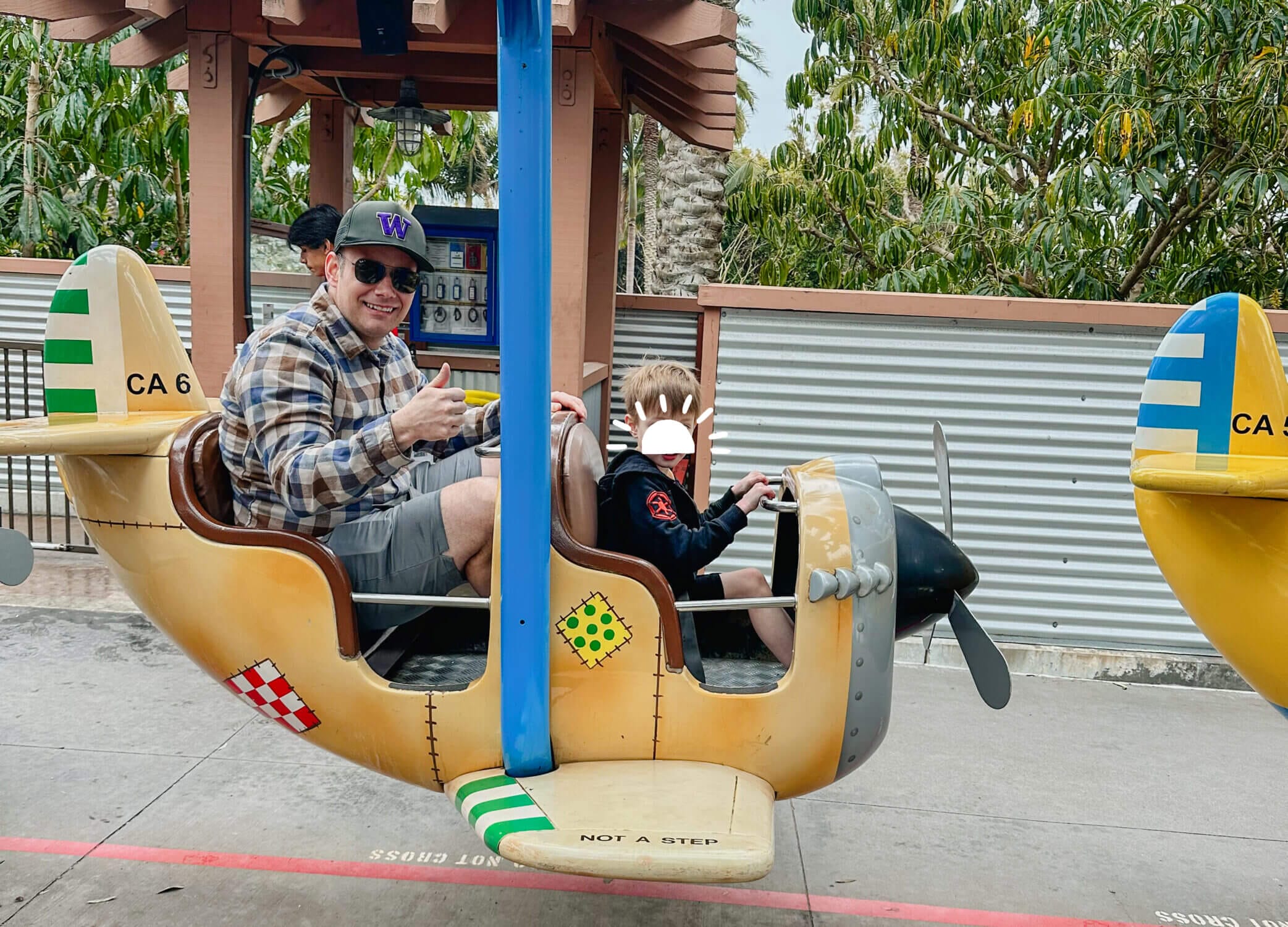 Dad and son enjoying the toddler-friendly Cargo Ace airplane ride at LEGOLAND California, a gentle spinning ride designed for young kids. With bright LEGO-themed planes and low height requirements, it’s one of the best attractions for preschoolers at the park, making LEGOLAND a top destination for families with little ones.