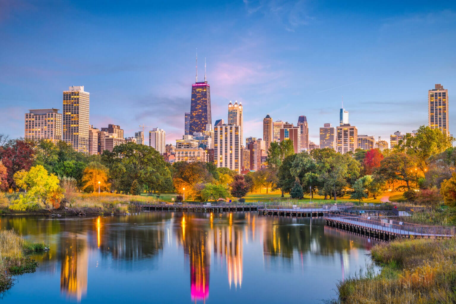 Twilight view of Chicago’s Lincoln Park with the city skyline glowing in the background, a peaceful spot where families can stroll, bike, or explore nature trails—one of the top things to do with kids in Chicago.