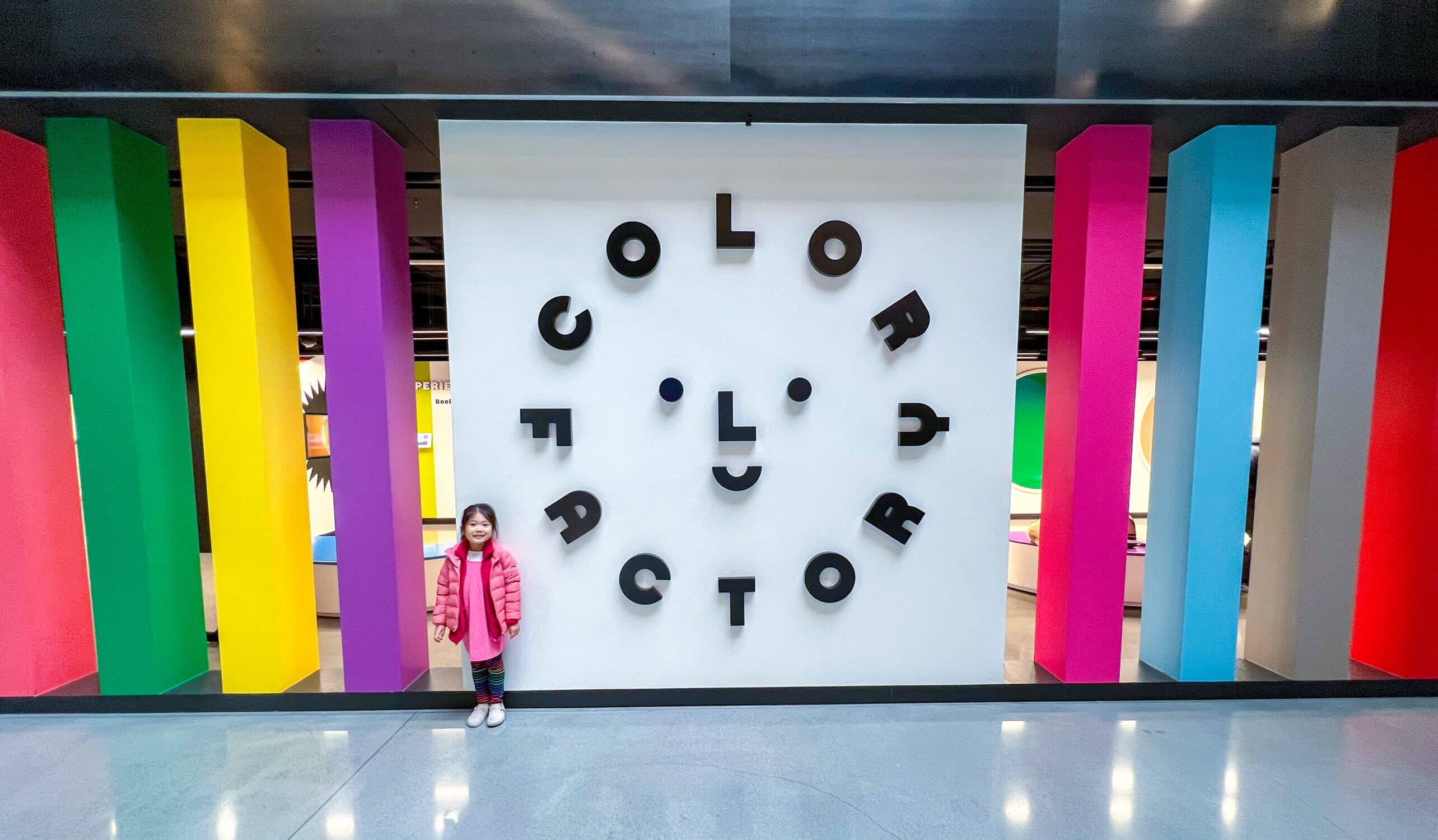 Young girl posing happily in front of the vibrant Color Factory sign in Chicago—one of her favorite attractions during the trip, known for its colorful immersive exhibits and interactive fun.