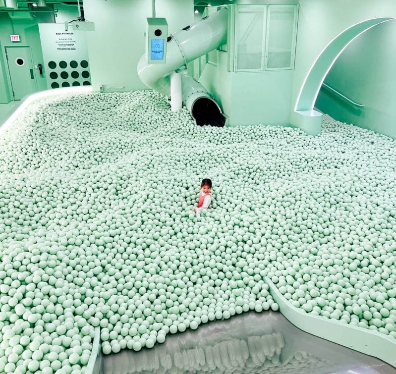 A young girl rode a slide into the massive ball pit at Color Factory Chicago, an immersive and colorful experience that was the highlight of our daughter’s trip—she still talks about it years later!