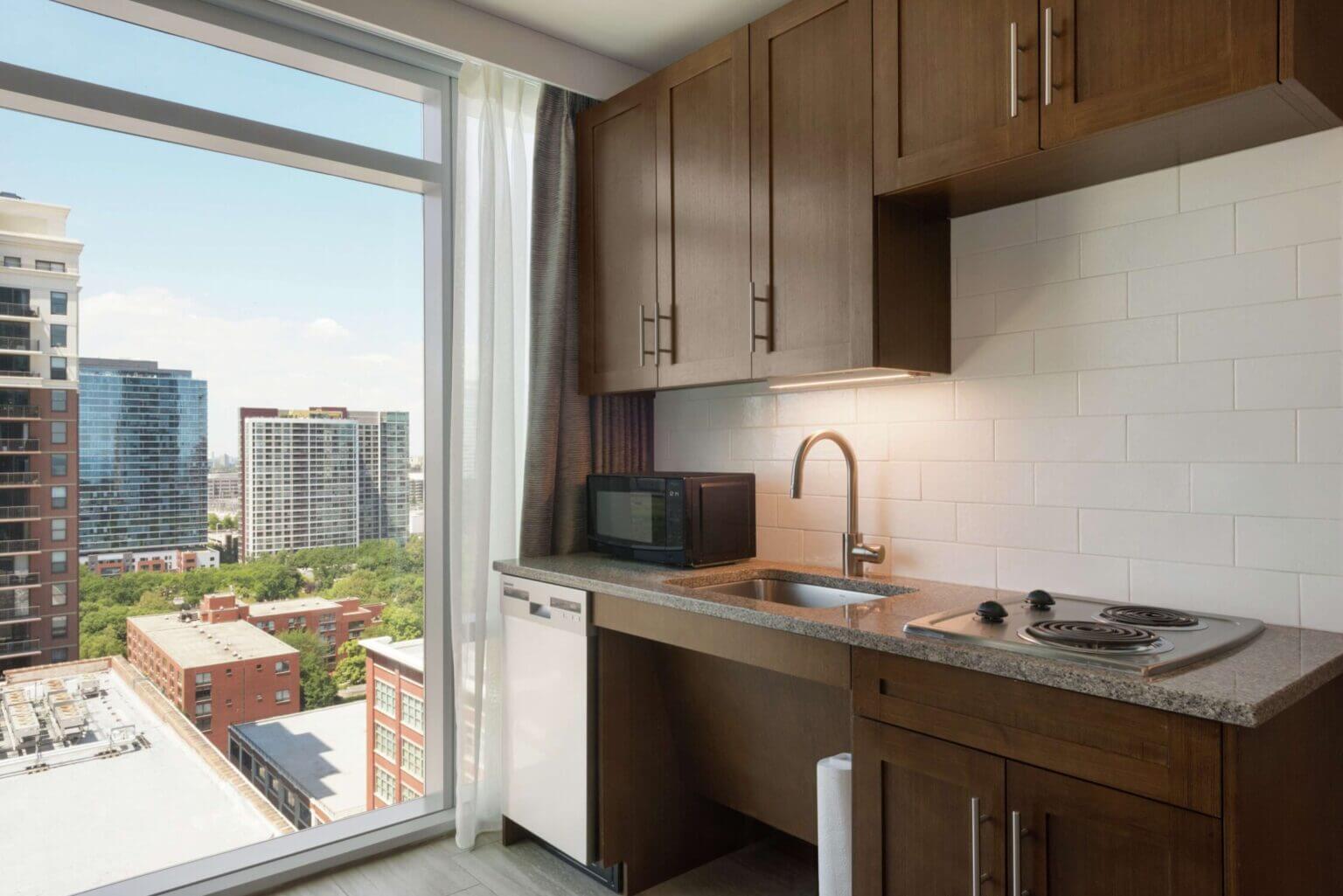 Indoor swimming pool at Homewood Suites by Hilton Chicago, featuring a clean, bright space with lounge chairs and large windows—perfect for families looking to unwind after exploring the city.