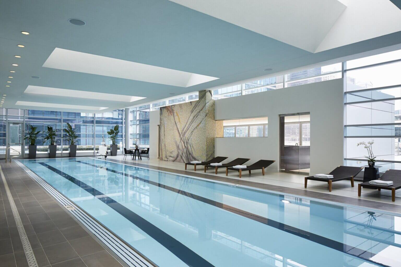 Indoor pool at Loews Chicago Hotel, a bright, modern swimming area with large windows, perfect for families to relax after a day exploring downtown Chicago.