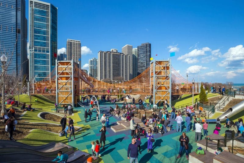 Maggie Daley Park playground near Millennium Park in downtown Chicago on a sunny day, filled with families and kids enjoying the unique climbing structures—one of the best kid-friendly attractions just east of the Bean.