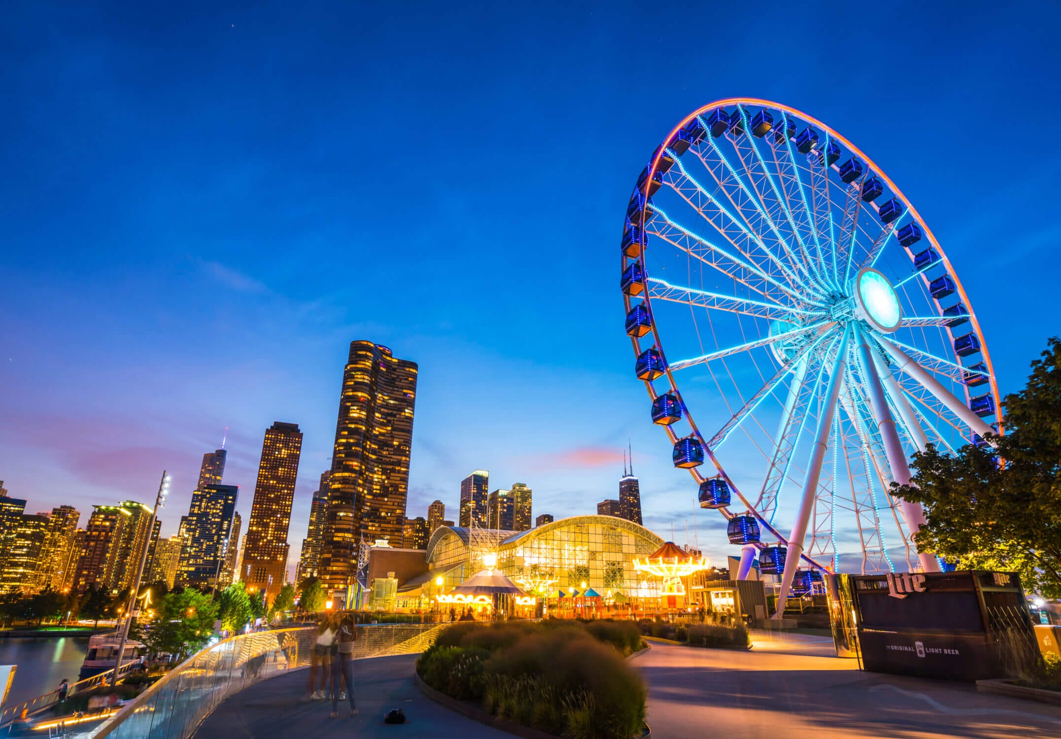 Navy Pier at night in Chicago with the skyline lit up in the background and the Ferris wheel glowing brightly—one of the top attractions for families visiting the city with kids.