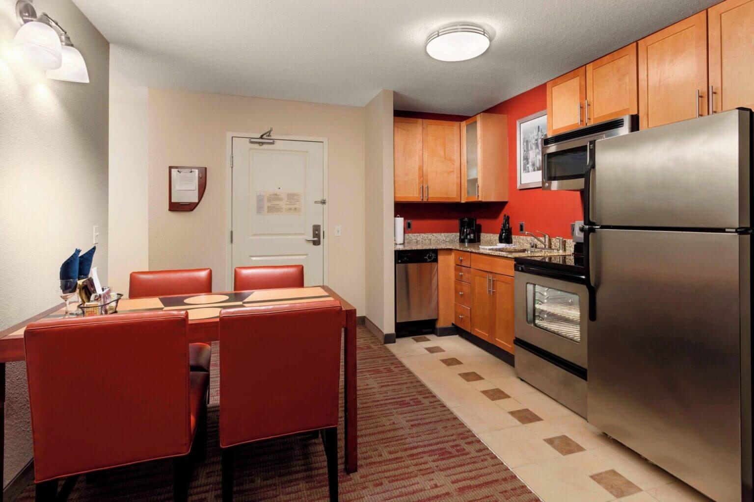 Interior of a modern studio room kitchen at Residence Inn by Marriott Chicago Downtown River North, featuring a full-size refrigerator, microwave, stove, sink, and countertop—ideal for families who prefer to cook or reheat meals during their Chicago stay.