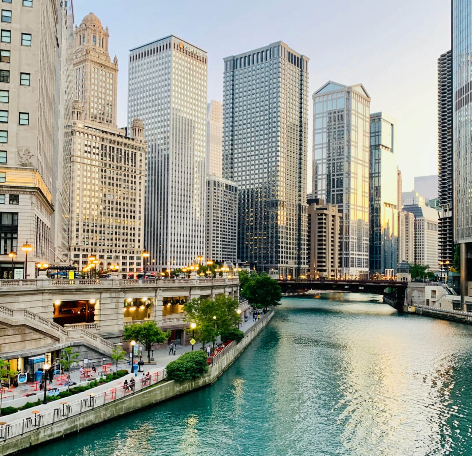 A scenic view of the River North neighborhood in Chicago, featuring the iconic Chicago Riverwalk with towering high-rises and renowned architecture lining the water—showcasing the city’s urban beauty and walkability.