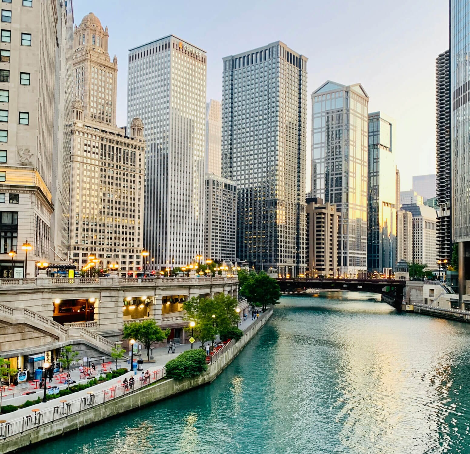 A scenic view of the River North neighborhood in Chicago, featuring the iconic Chicago Riverwalk with towering high-rises and renowned architecture lining the water—showcasing the city’s urban beauty and walkability.