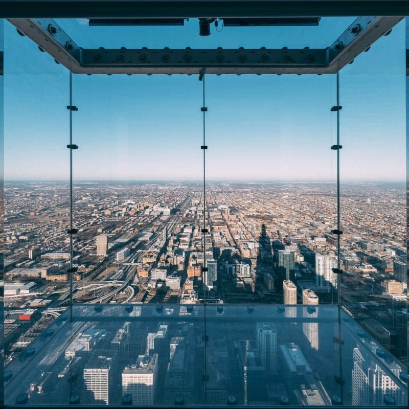 View from the Skydeck at Willis Tower on a clear Chicago day, showing the famous glass box extending over the city with no one inside — a thrilling experience and a must-visit for families looking for things to do with kids in Chicago.