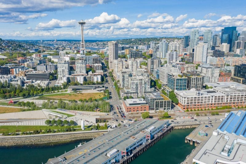 Aerial view of Belltown Seattle with the iconic Space Needle and Olympic Sculpture Park in view, highlighting this walkable and vibrant neighborhood near family attractions.