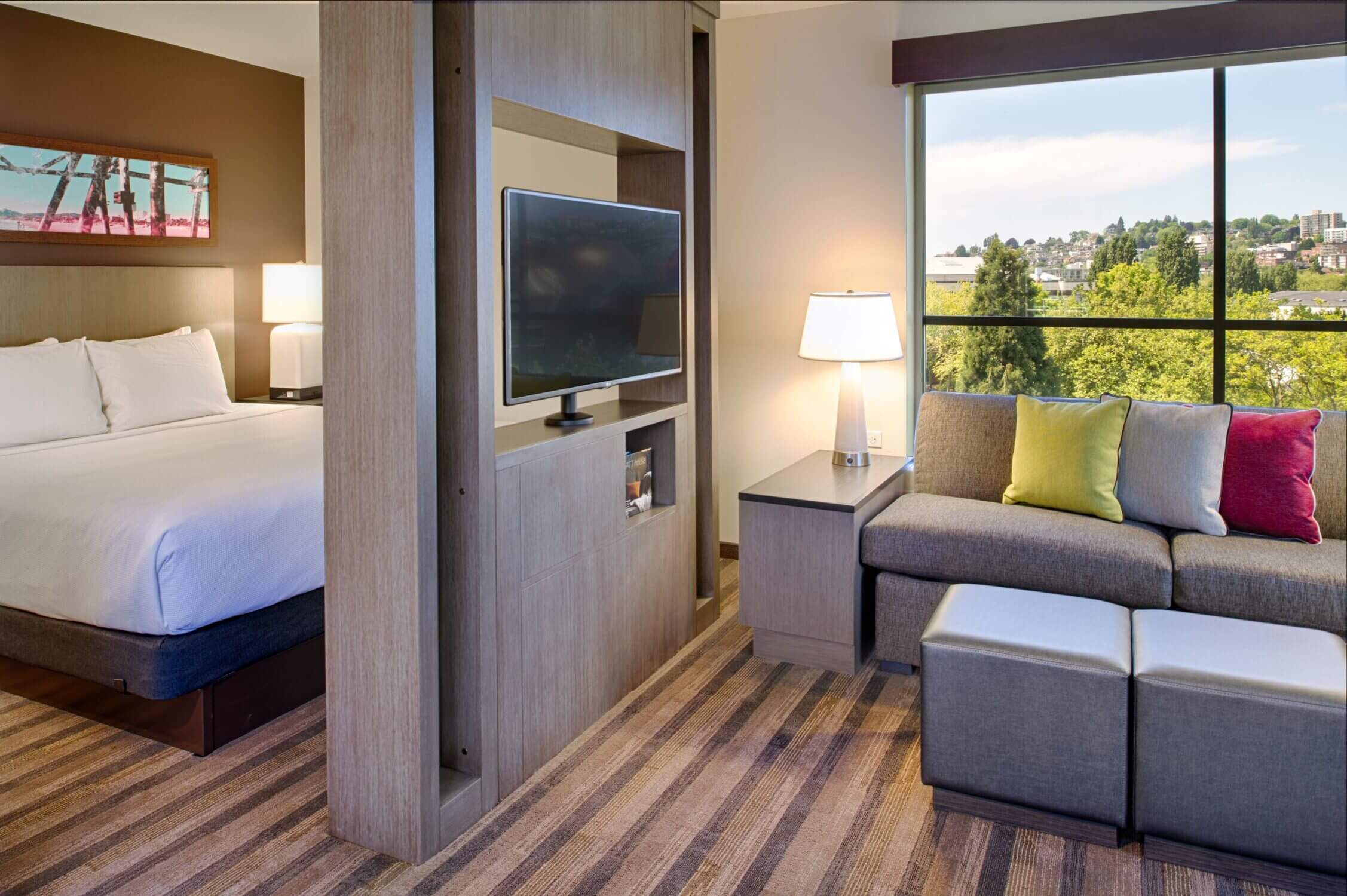 Interior view of a studio suite at Hyatt House in Seattle’s Queen Anne neighborhood, featuring a bedroom and separate living room area—perfect for families looking for extra space and comfort while visiting with kids.
