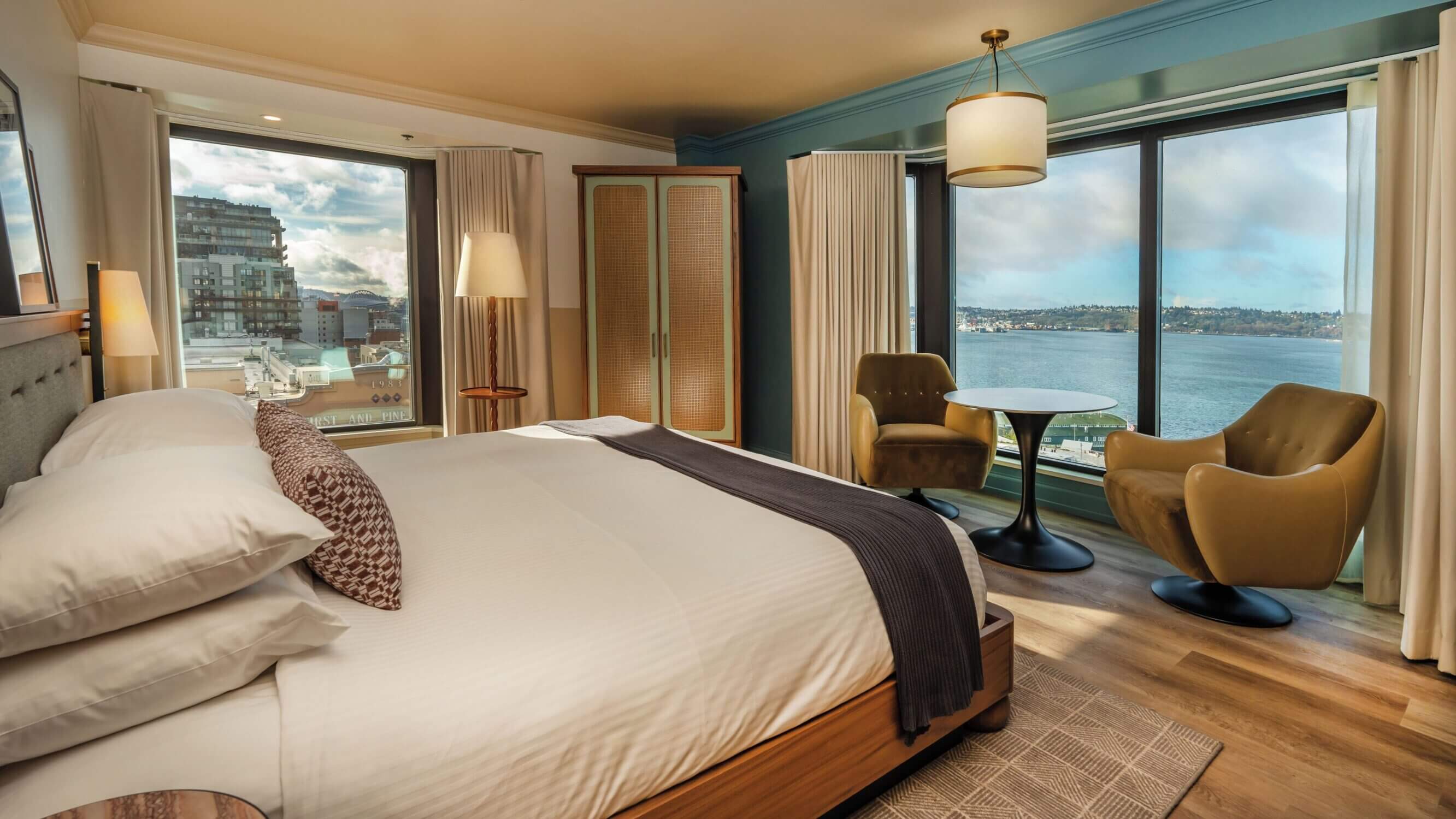 King bed room at Inn at the Market with stunning bay view, overlooking the rooftops of Pike Place Market and the Seattle waterfront. A peaceful, centrally located hotel that’s one of the best places to stay with kids near Pike Place Market.